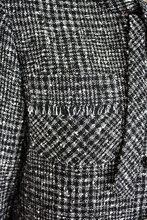 ツイードの柄をいかして、バイアスと縦地の間にフリンジをほどこしたアウトポケットのデザインのブラウスは、立体裁断でパターン作り